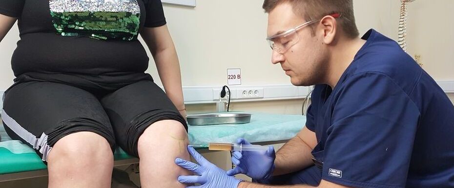 An orthopedic doctor makes a fine injection into the knee joint for osteoarthritis