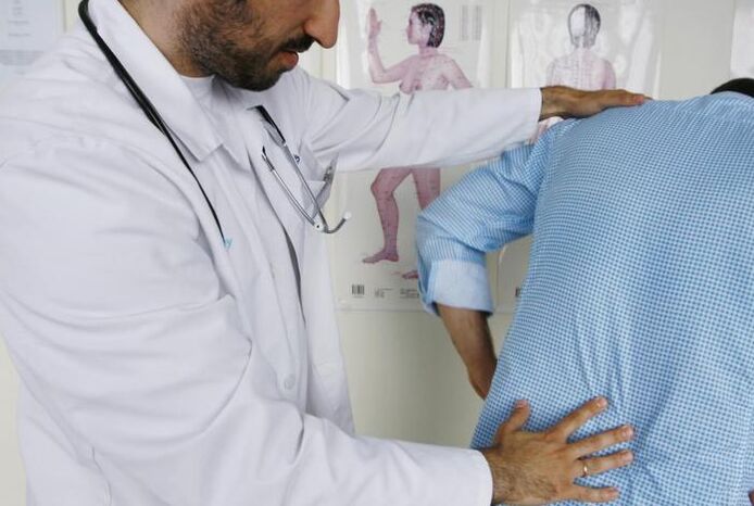 A doctor examining a patient with low back pain